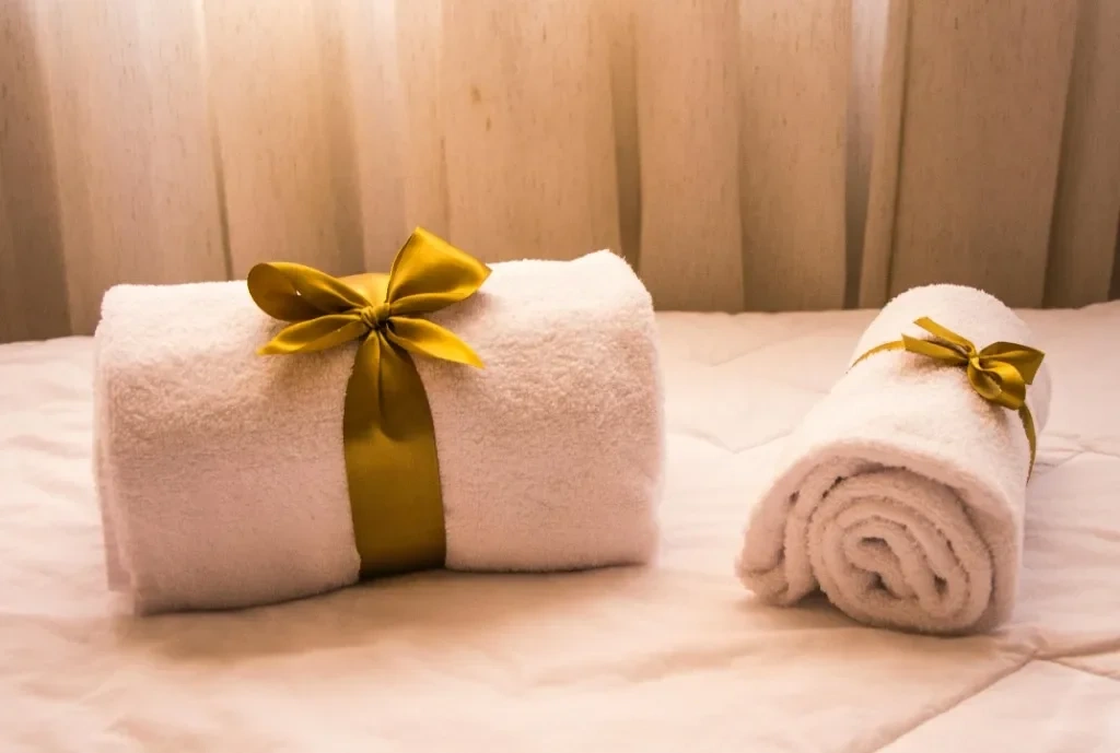 Bespoke Airbnb turnover cleaning setup featuring neatly rolled white towels with a golden ribbon, showcasing Splash Maids' attention to detail and hotel-standard hospitality.