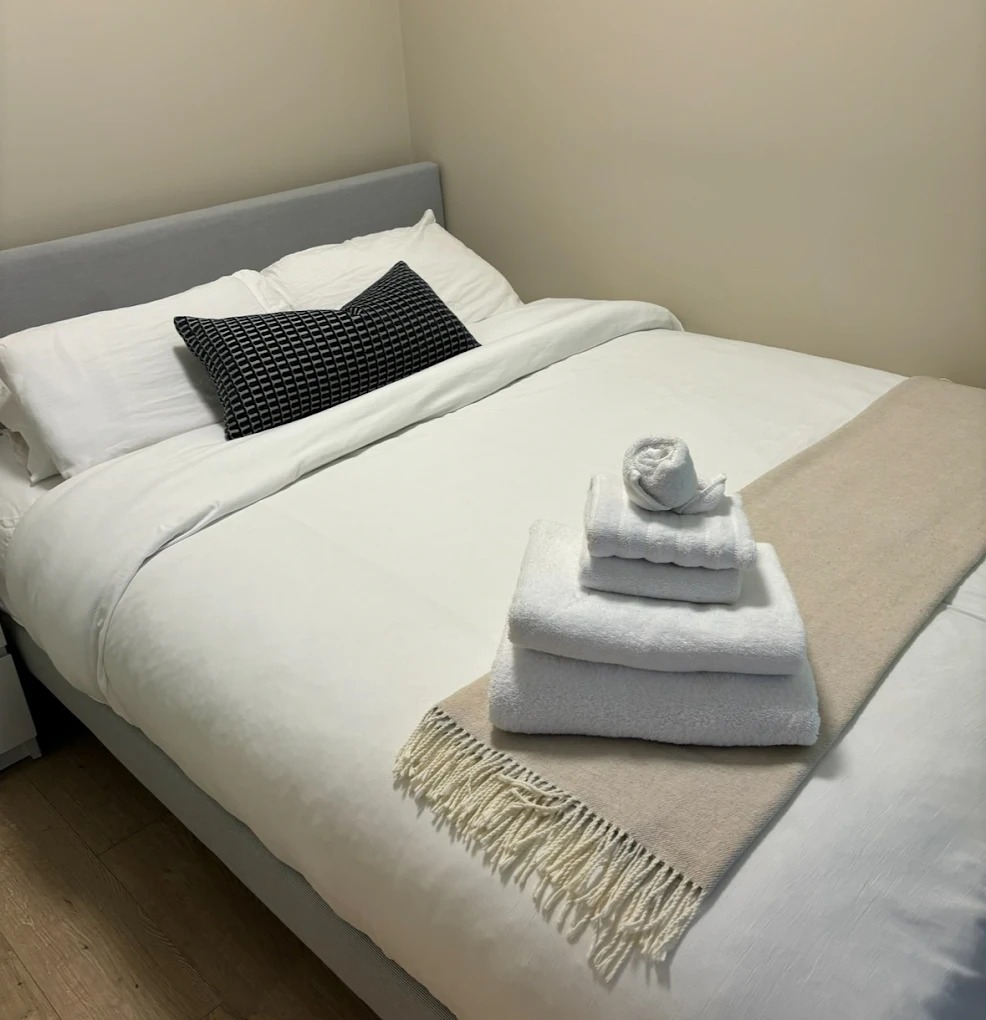 Pristine white linens on made bed in Airbnb turnover clean by Splash Maids