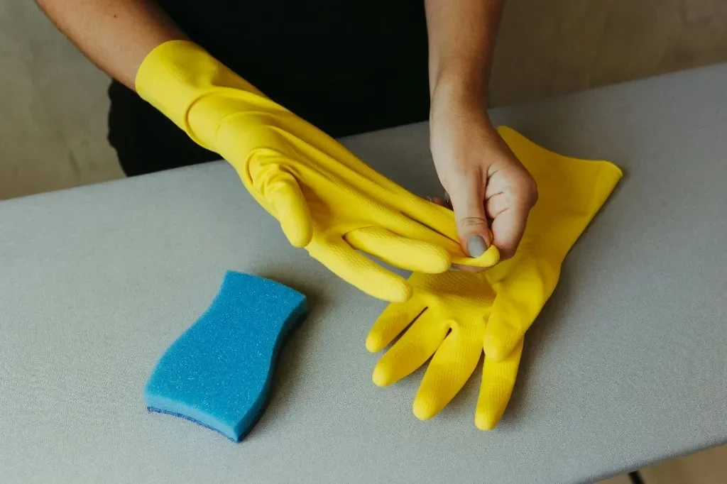 Professional cleaner gearing up with yellow gloves and sponge for deep cleaning